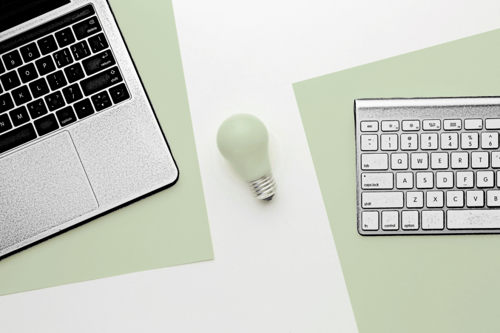 ntree GmbH - Tastaturen links und rechts und Glühbirne in der Mitte als Symbol für textliche Inspiration hinsichtlich Content Marketing