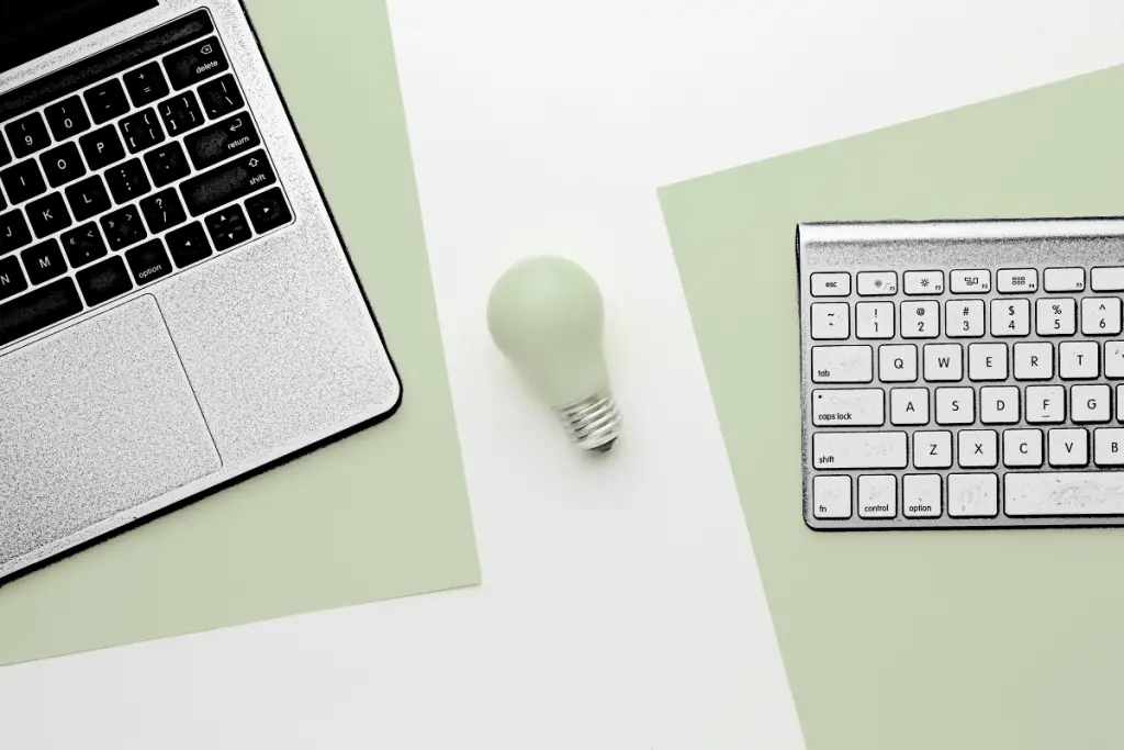 ntree GmbH - Tastaturen links und rechts und Glühbirne in der Mitte als Symbol für textliche Inspiration hinsichtlich Content Marketing